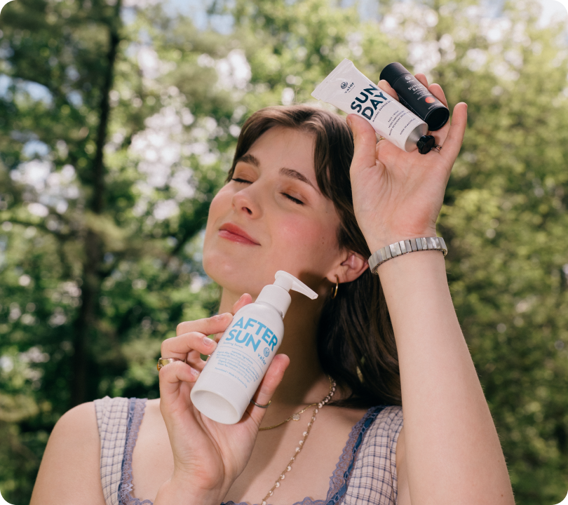 Woman outdoors holding sun care products